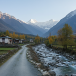 A quiet mountain road winding along a river toward snow-capped Himalayan peaks in a secluded valley.