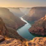 Dramatic red granite cliff face and winding river gorge in Gandikota under soft morning sunlight.