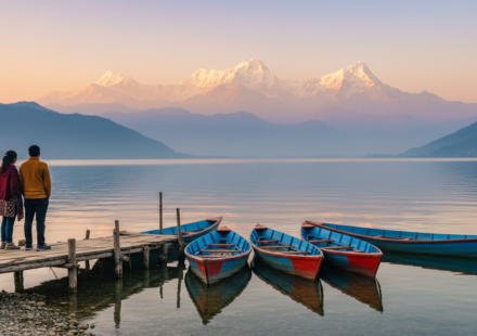 Colorful wooden boats resting on Phewa Lake in Pokhara with the snow-capped Annapurna mountain range in the background.