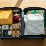 Open suitcase packed with colorful Indian ethnic outfits, embroidered juttis, and a velvet jewelry box.