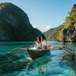 An Indian couple sitting on a traditional bangka boat floating on clear turquoise lagoon waters in El Nido.
